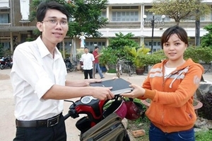 （C）Lao dong、被害者に財産を引き渡すアインさん(右)