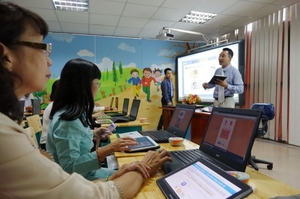（C）Tuoi tre,Nhu Hung、電子教科書の説明を受ける教育関係者ら