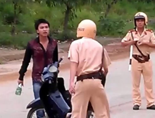 (C)giaoduc.net, 叩き割ったビール瓶を手に警察官に近づく若者