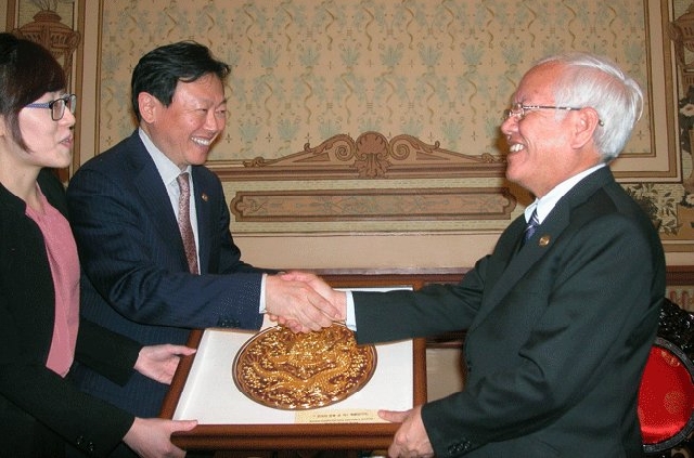 (C)ホーチミン市人民委員会クアン主席(右)と握手するシン会長